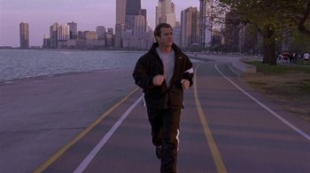 Movie still from “What Women Want” (2000), directed by Nancy Meyers – A man is running down the street near a body of water; Wide shot, High angle