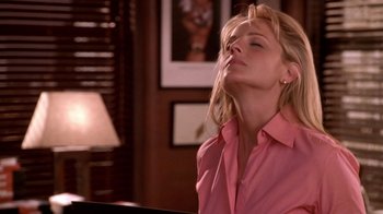 Movie still from “What Women Want” (2000), directed by Nancy Meyers – A woman in a pink shirt sitting in front of a piano; Close Up shot, Low angle