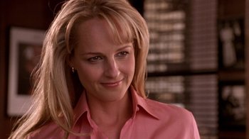 Movie still from “What Women Want” (2000), directed by Nancy Meyers – A woman in a pink shirt smiling for the camera; Close Up shot, Over the shoulder angle