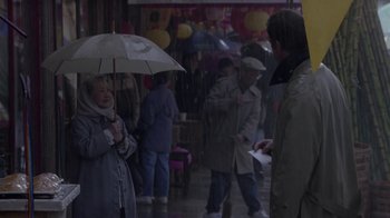 Movie still from “What Women Want” (2000), directed by Nancy Meyers – A woman holding an umbrella while standing in the rain; Medium shot, Over the shoulder angle
