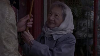 Movie still from “What Women Want” (2000), directed by Nancy Meyers – An older woman holding a stick in her hand; Close Up shot, Over the shoulder angle