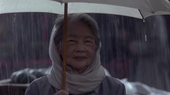 Movie still from “What Women Want” (2000), directed by Nancy Meyers – An older woman holding an umbrella in the rain; Close Up shot, Low angle