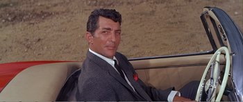 Movie still from “What a Way to Go!” (1964), directed by J. Lee Thompson – A person wearing a suit and tie; Close Up shot, Low angle