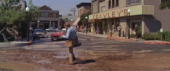 Movie still from “What a Way to Go!” (1964), directed by J. Lee Thompson – A man is standing in the middle of the street; Wide shot, High angle