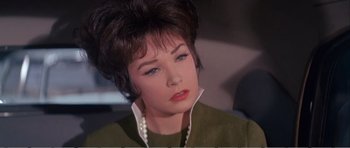 Movie still from “What a Way to Go!” (1964), directed by J. Lee Thompson – A person wearing a green shirt and pearls; Close Up shot, Low angle