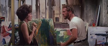 Movie still from “What a Way to Go!” (1964), directed by J. Lee Thompson – A man and a woman are talking in front of a painting; Medium shot, Over the shoulder angle