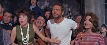 Movie still from “What a Way to Go!” (1964), directed by J. Lee Thompson – A group of people standing next to each other in a room; Medium shot, Low angle