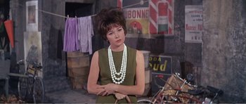 Movie still from “What a Way to Go!” (1964), directed by J. Lee Thompson – A woman in a green dress and a white necklace; Close Up shot, Low angle