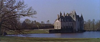Movie still from “What a Way to Go!” (1964), directed by J. Lee Thompson – A large house with a large body of water in front of it; Extreme Wide shot, High angle