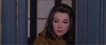 Movie still from “What a Way to Go!” (1964), directed by J. Lee Thompson – A young woman in a brown sweater looking at the camera; Close Up shot, High angle