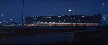 Movie still from “What a Way to Go!” (1964), directed by J. Lee Thompson – A building that is lit up at night time; Extreme Wide shot, Low angle