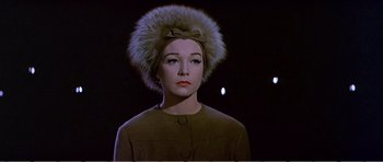 Movie still from “What a Way to Go!” (1964), directed by J. Lee Thompson – A woman wearing a fur hat with a bow in front of a dark background; Close Up shot, Low angle
