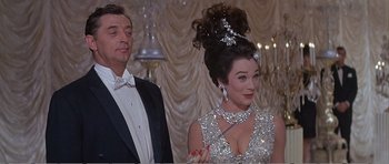 Movie still from “What a Way to Go!” (1964), directed by J. Lee Thompson – A man and a woman standing next to each other in a room; Medium shot, Low angle