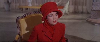 Movie still from “What a Way to Go!” (1964), directed by J. Lee Thompson – A woman in a red coat and a red hat; Close Up shot, High angle