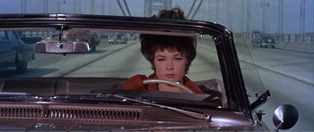 Movie still from “What a Way to Go!” (1964), directed by J. Lee Thompson – A woman sitting in the back seat of a car looking out of the window; Close Up shot, Low angle