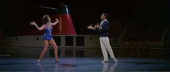 Movie still from “What a Way to Go!” (1964), directed by J. Lee Thompson – A man and a woman are dancing on a stage; Wide shot, High angle