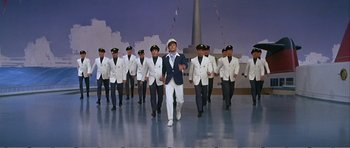 Movie still from “What a Way to Go!” (1964), directed by J. Lee Thompson – A group of men in white jackets and hats; Wide shot, Low angle