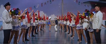 Movie still from “What a Way to Go!” (1964), directed by J. Lee Thompson – A group of people are dancing on a stage; Wide shot, High angle