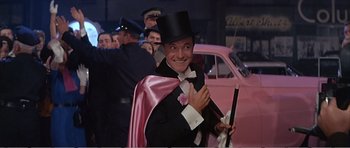 Movie still from “What a Way to Go!” (1964), directed by J. Lee Thompson – A man in a tuxedo and top hat holding a cane; Medium shot, Low angle