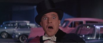 Movie still from “What a Way to Go!” (1964), directed by J. Lee Thompson – A person wearing a top hat and a bow tie; Close Up shot, Low angle