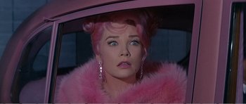 Movie still from “What a Way to Go!” (1964), directed by J. Lee Thompson – A person wearing a pink wig; Close Up shot, Low angle