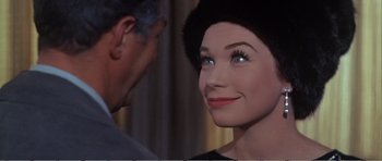 Movie still from “What a Way to Go!” (1964), directed by J. Lee Thompson – A man standing next to a woman's face; Close Up shot, Over the shoulder angle
