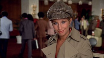 Movie still from “What's Up, Doc?” (1972), directed by Peter Bogdanovich – A woman wearing a hat and a trench coat; Close Up shot, High angle