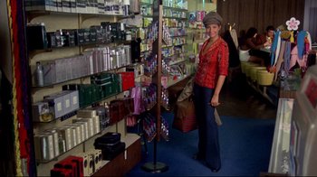 Movie still from “What's Up, Doc?” (1972), directed by Peter Bogdanovich – A woman standing in front of a display in a store; Wide shot, High angle