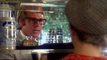 Movie still from “What's Up, Doc?” (1972), directed by Peter Bogdanovich – A man with glasses is looking into a mirror; Close Up shot, Over the shoulder angle