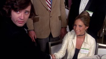 Movie still from “What's Up, Doc?” (1972), directed by Peter Bogdanovich – A man and a woman shaking hands in front of a group of people; Medium shot, Over the shoulder angle