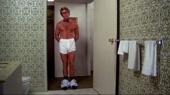 Movie still from “What's Up, Doc?” (1972), directed by Peter Bogdanovich – A man standing in his underwear in a bathroom; Medium shot, Low angle