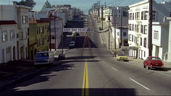 Movie still from “What's Up, Doc?” (1972), directed by Peter Bogdanovich – An empty street in a residential area with cars parked on the side of the road; Extreme Wide shot, High angle