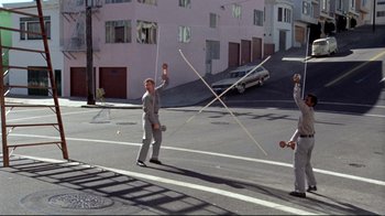 Movie still from “What's Up, Doc?” (1972), directed by Peter Bogdanovich – Two men in suits are playing a game on the street; Wide shot, High angle