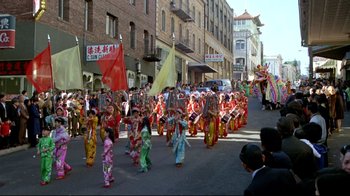 Movie still from “What's Up, Doc?” (1972), directed by Peter Bogdanovich – A group of people in colorful costumes marching down a street; Extreme Wide shot, High angle