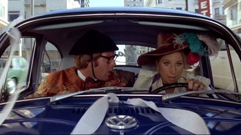 Movie still from “What's Up, Doc?” (1972), directed by Peter Bogdanovich – A man and a woman sitting in the back seat of a car; Medium shot, Over the shoulder angle