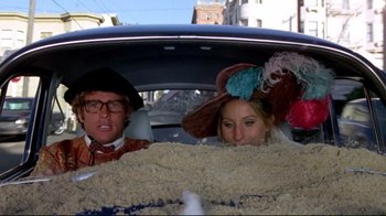 Movie still from “What's Up, Doc?” (1972), directed by Peter Bogdanovich – A man and a woman sitting in the back of a car; Medium shot, High angle