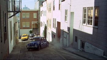 Movie still from “What's Up, Doc?” (1972), directed by Peter Bogdanovich – An old car parked on the side of the street; Extreme Wide shot, High angle