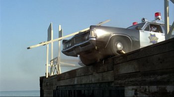 Movie still from “What's Up, Doc?” (1972), directed by Peter Bogdanovich – An old police car on the side of the road; Wide shot, Low angle