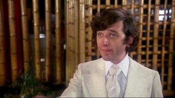 Movie still from “What's Up, Doc?” (1972), directed by Peter Bogdanovich – A man in a white suit and a white tie; Close Up shot, Low angle