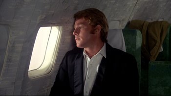 Movie still from “What's Up, Doc?” (1972), directed by Peter Bogdanovich – A man sitting on a plane looking out the window; Close Up shot, Low angle