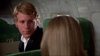 Movie still from “What's Up, Doc?” (1972), directed by Peter Bogdanovich – A man and a woman sitting on a plane; Close Up shot, Over the shoulder angle