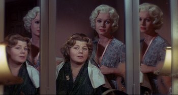 Movie still from “What's the Matter with Helen?” (1971), directed by Curtis Harrington – Two women standing next to each other in front of a mirror; Medium shot, Over the shoulder angle