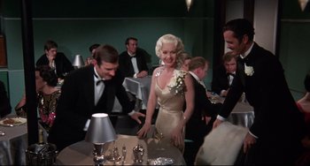 Movie still from “What's the Matter with Helen?” (1971), directed by Curtis Harrington – A group of people standing around a table with wine glasses on it; Medium shot, Over the shoulder angle