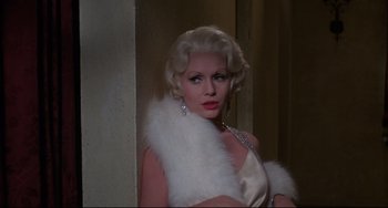 Movie still from “What's the Matter with Helen?” (1971), directed by Curtis Harrington – A woman in a white dress and a white fur stole; Close Up shot, Over the shoulder angle