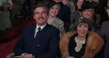 Movie still from “What's the Matter with Helen?” (1971), directed by Curtis Harrington – A group of people sitting in a room with hats on; Medium shot, High angle