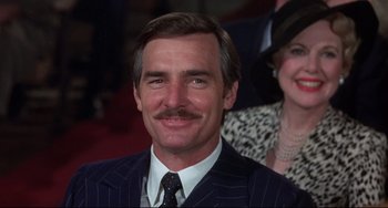 Movie still from “What's the Matter with Helen?” (1971), directed by Curtis Harrington – A person wearing a suit and tie; Close Up shot, Low angle