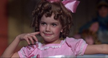 Movie still from “What's the Matter with Helen?” (1971), directed by Curtis Harrington – A little girl in a pink dress with a bow; Close Up shot, Over the shoulder angle