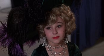 Movie still from “What's the Matter with Helen?” (1971), directed by Curtis Harrington – A young girl wearing a green dress and a black hat; Close Up shot, High angle
