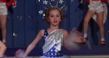 Movie still from “What's the Matter with Helen?” (1971), directed by Curtis Harrington – A little girl wearing a star headband and holding a frisbee in her hand; Medium shot, Low angle