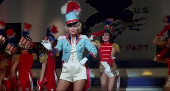 Movie still from “What's the Matter with Helen?” (1971), directed by Curtis Harrington – A group of women dressed up in costumes on a stage; Wide shot, Low angle